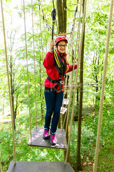 Teenager girl climbing in high rope course or parl Stock photo © Kzenon