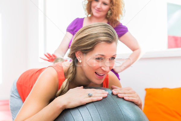 Pregnant young women getting backrub with spiky massage ball Stock photo © Kzenon