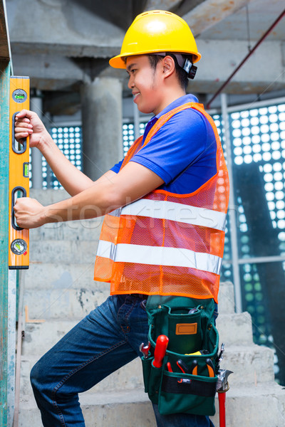 Builder or worker controlling wall on construction site Stock photo © Kzenon
