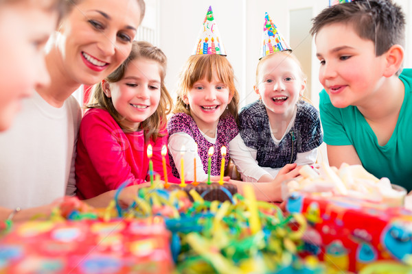 Gyermek születésnapi buli fúj gyertyák torta barátok Stock fotó © Kzenon