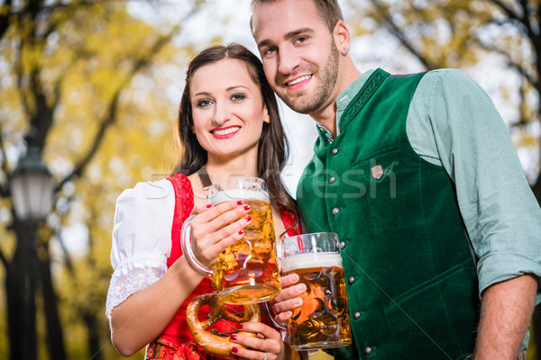 Couple in Dirndl and Tracht having Pretzel and Bier  Stock photo © Kzenon