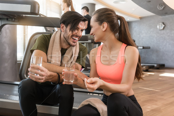 Cheerful young man and woman drinking plain water during break a Stock photo © Kzenon