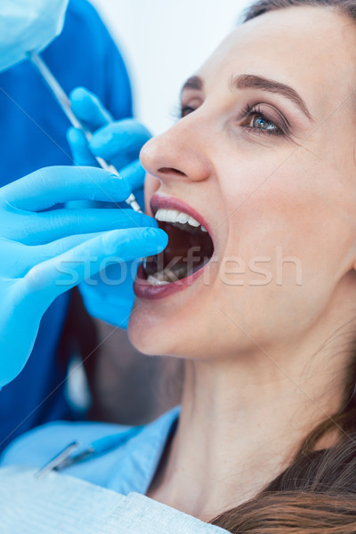 Close-up of the hands of a dentist cleaning the teeth of a young woman Stock photo © Kzenon