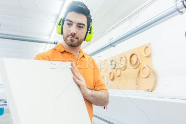 Carpenter in furniture factory working on veneer machine Stock photo © Kzenon