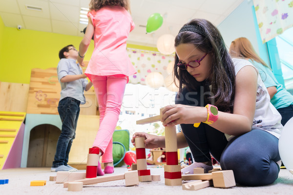 Cute girl building a structure in balance during playtime at the kindergarten Stock photo © Kzenon