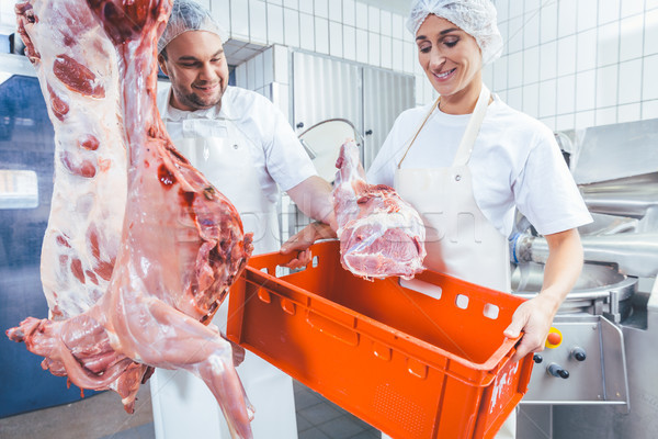 Team of butchers working with meat in butchery Stock photo © Kzenon