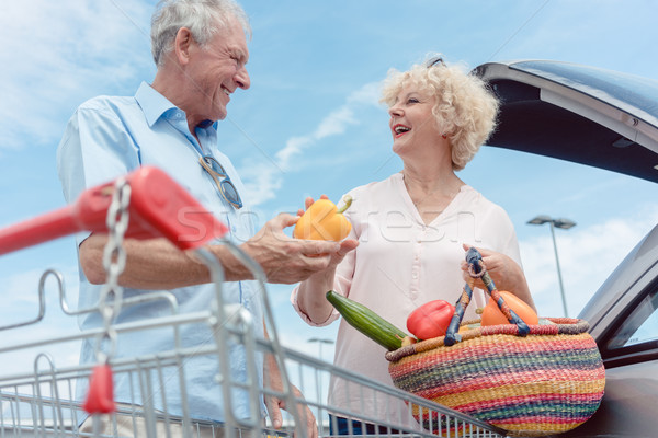 Cheerful senior couple happy for buying fresh vegetables from the hypermarket Stock photo © Kzenon