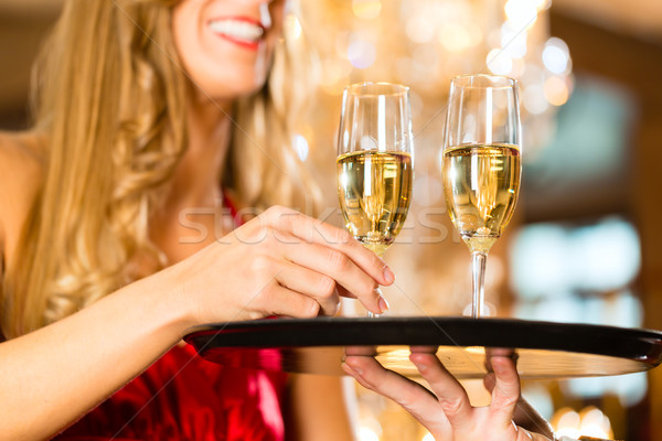 Waiter serves champagne glasses on tray in restaurant Stock photo © Kzenon