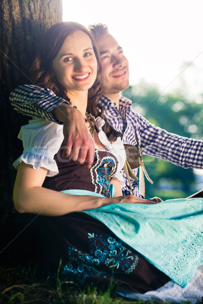 Bavarian couple in Tracht hugging under tree Stock photo © Kzenon