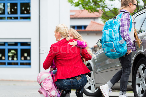 Mother hugging child after bringing her to school Stock photo © Kzenon