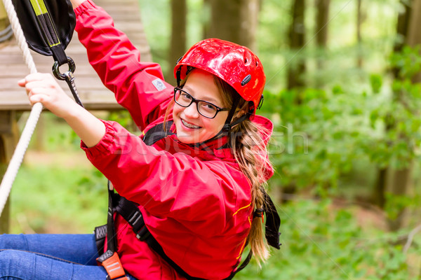 Stock photo: Child reaching platform climbing in high rope course