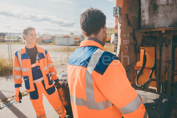 Garbage man and women cleaning dustbins into waste truck Stock photo © Kzenon