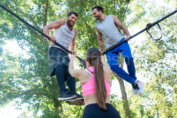 Fit woman showing thumbs up to her friends during extreme workout Stock photo © Kzenon