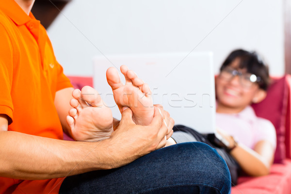 Stock photo: Asian couple on the couch with a laptop