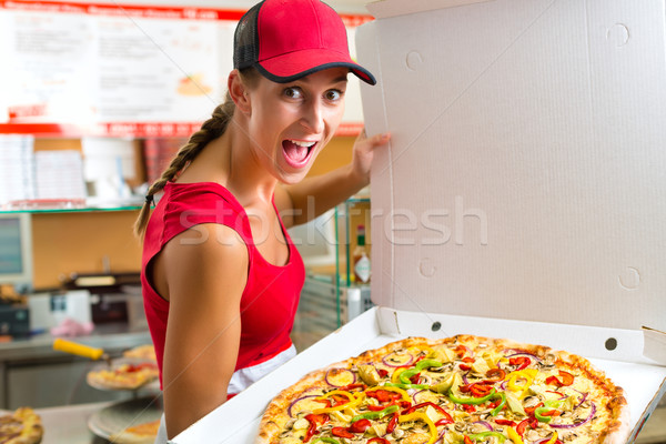 Woman holding a whole pizza in hand Stock photo © Kzenon