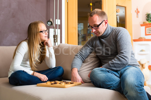 Father and daughter playing checkers Stock photo © Kzenon