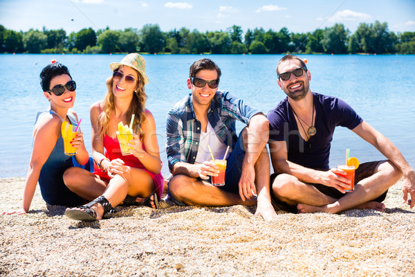 Quatre amis séance lac plage cocktails [[stock_photo]] © Kzenon