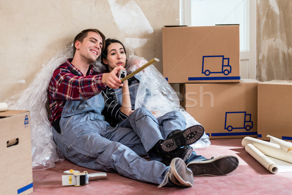 Young couple day dreaming about their future after moving in new home Stock photo © Kzenon