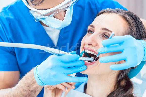 Young woman during painless oral treatment in a modern dental office Stock photo © Kzenon