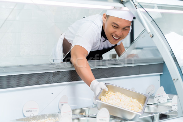 Glimlachend asian chef vulling display counter Stockfoto © Kzenon
