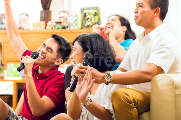 Asian people singing at karaoke party Stock photo © Kzenon