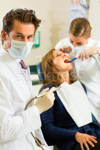 Dentista cirugía dentistas perforación mirando ayudante Foto stock © Kzenon