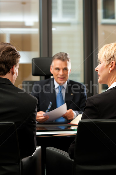 Lawyer or notary with clients in his office Stock photo © Kzenon