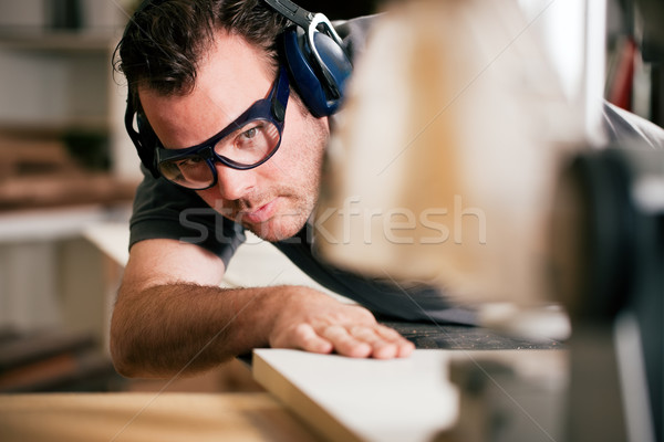 Carpenter using electric saw Stock photo © Kzenon