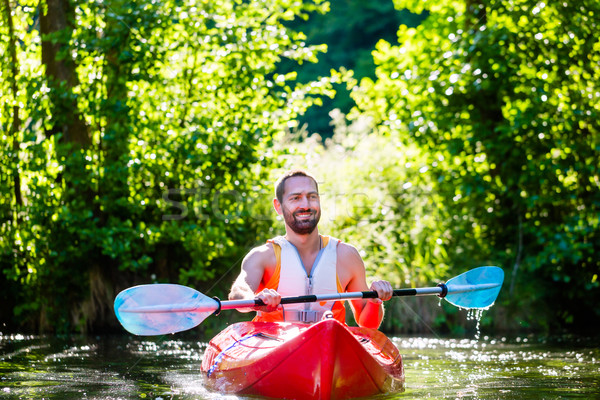 Man paddling with kayak on river for water sport Stock photo © Kzenon