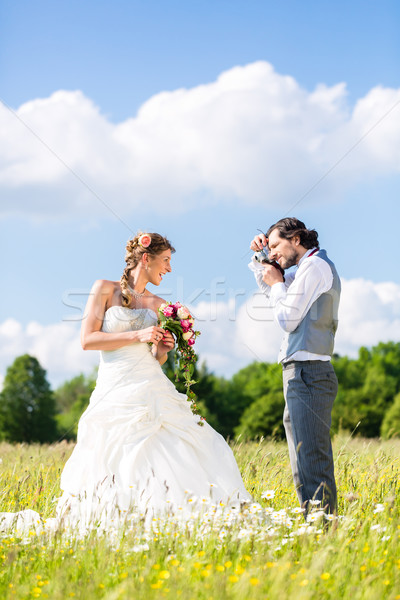 Wedding couple taking pictures on meadow Stock photo © Kzenon