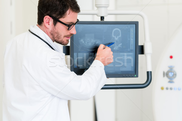 Doctor explaining image of MRI scan on screen Stock photo © Kzenon