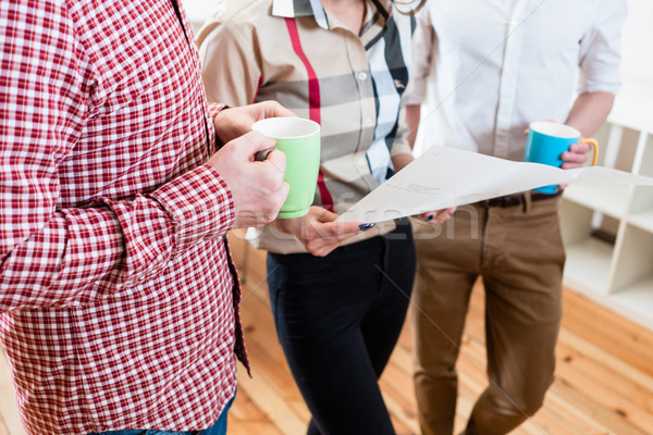 Men and woman in casual office looking at plan Stock photo © Kzenon