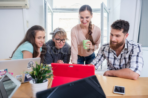 Stock photo: Four co-workers watching a business presentation in a modern shared office space