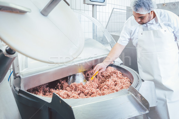 Butcher checking minced meat for the right quality Stock photo © Kzenon