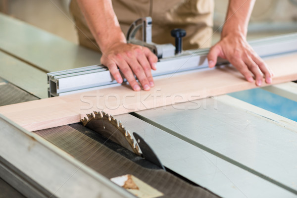 Carpenter cutting wooden board with circular saw Stock photo © Kzenon