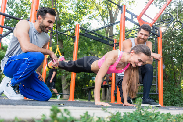 Fit woman doing leg extension with suspension trainer motivated  Stock photo © Kzenon