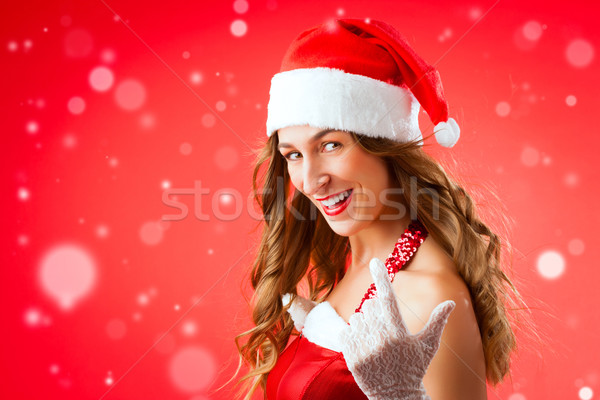 Stock photo: Attractive young woman in Santa Claus costume alluring gesture