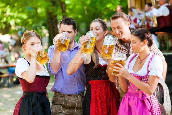 In Beer garden - friends in front of band Stock photo © Kzenon