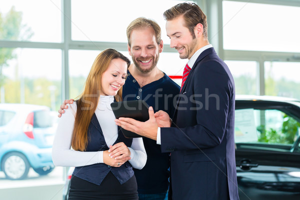 Dealer, clients and auto in car dealership Stock photo © Kzenon