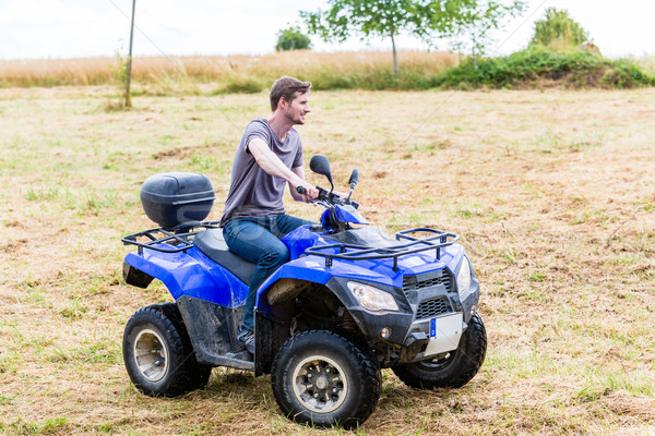 Stock photo: Man driving off-road with quad bike or ATV