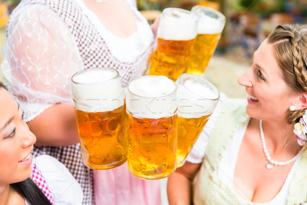 Waitress serving beer in five beer glasses Stock photo © Kzenon