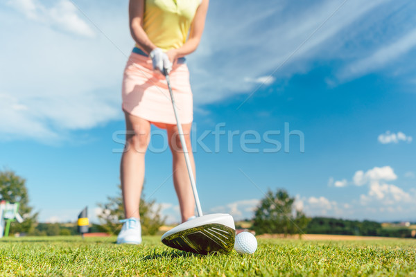 Stock photo: Close-up of a golf ball next to a professional club held by a fe