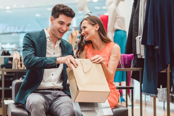 Woman showing her man what she bought in fashion store Stock photo © Kzenon