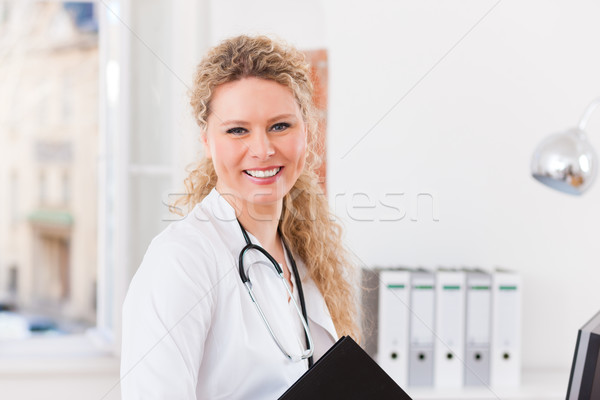 Portrait of young female doctor in clinic with file Stock photo © Kzenon