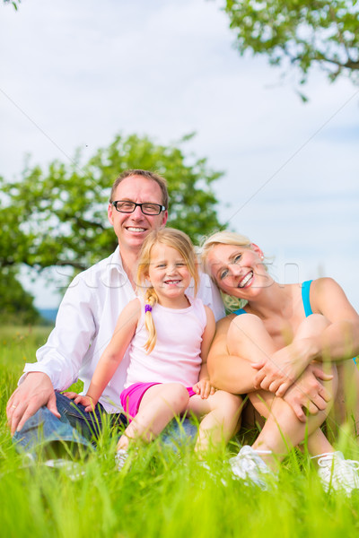 Family sitting on grass of lawn or field Stock photo © Kzenon