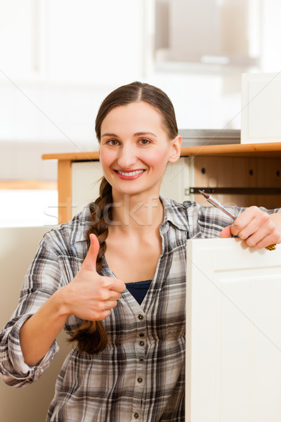 Young woman is assembling a cupboard Stock photo © Kzenon