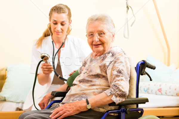 Fiatal nővér női idős öregek otthona vérnyomás Stock fotó © Kzenon