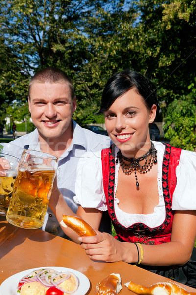 Couple in beer garden eating and drinking Stock photo © Kzenon