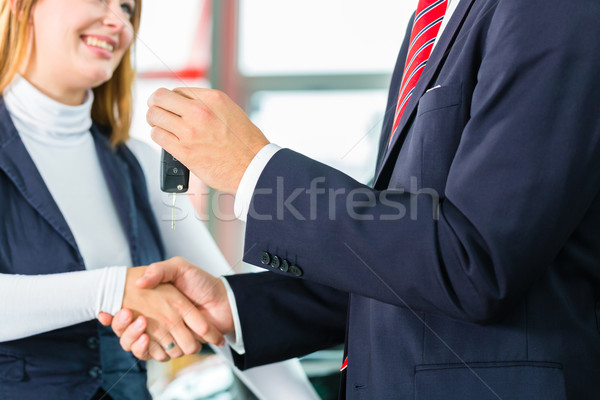 Young woman and seller with auto in car dealership Stock photo © Kzenon