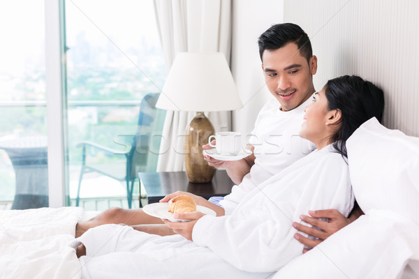 Asian couple lounging in bed at morning Stock photo © Kzenon